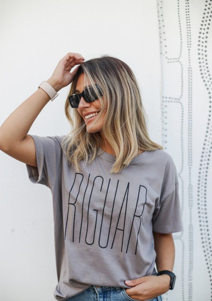 Girl wearing Riguar T-Shirt Small11 Women in a grey t-shirt with the text Riguar on the front